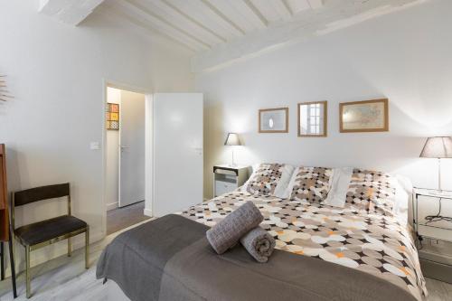 une chambre blanche avec un lit et une chaise dans l'établissement Vintage by Cocoonr, à Rennes