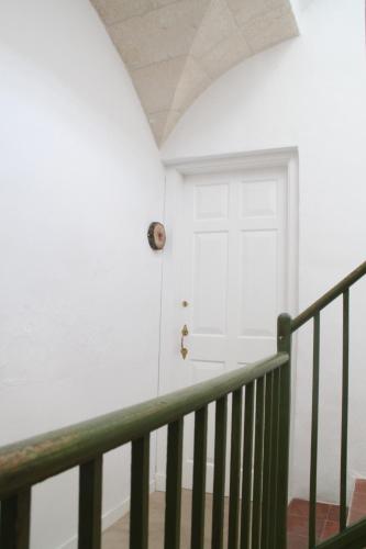 a white door in a white wall with a railing at S'Esparteria Hotel in Ciutadella