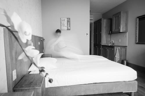 a bedroom with a bed with white sheets at Hotel Beemster in Middenbeemster