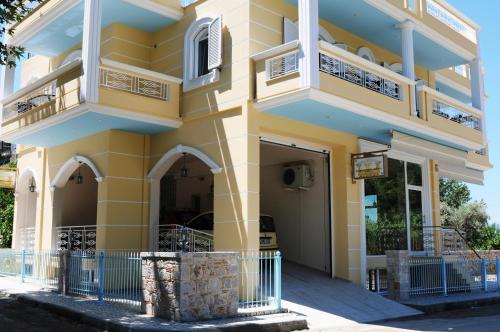 a yellow building with balconies on a street at Royal's Studios in Loutra Edipsou