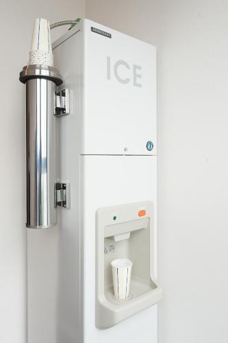 a white ice machine with a cup in it at Hotel Gracery Sapporo in Sapporo