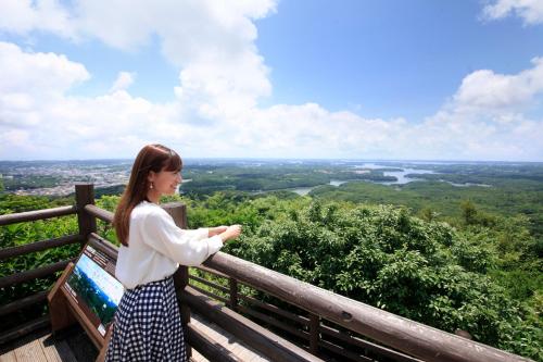 a woman standing on top of a lookout tower at Quintessa Hotel Iseshima in Shima