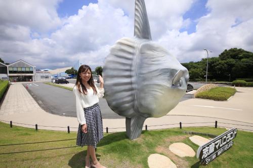 a woman standing next to a statue of a fish at Quintessa Hotel Iseshima in Shima
