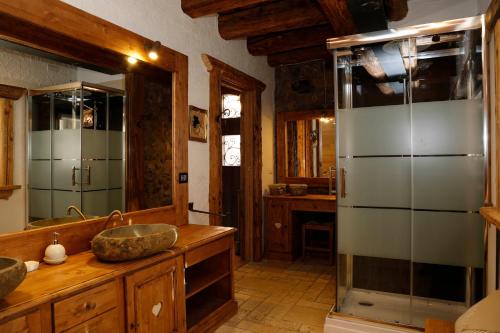 a bathroom with two sinks and a glass shower at Albergo Diffuso Zoncolan in Ovaro