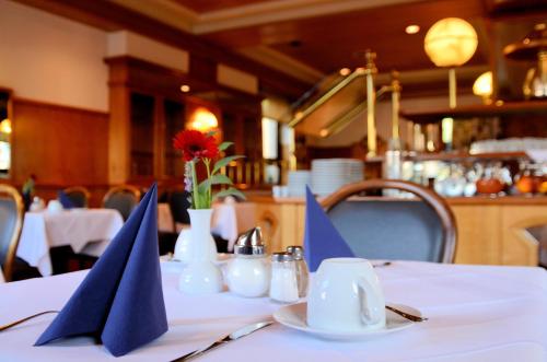 a table with blue napkins on a table in a restaurant at Hotel Altbacher Hof in Altbach