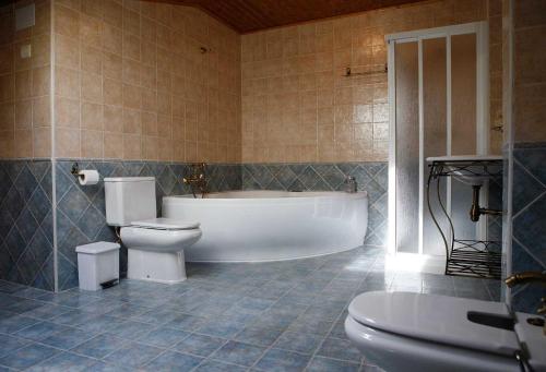 a bathroom with a tub and a toilet and a sink at Hotel Rural La Plazuela in Aldealengua