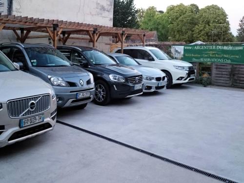 Une rangée de voitures garées sur un parking dans l'établissement Le Gite du Chevalier, à Loches