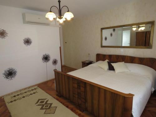 a bedroom with a large bed and a mirror at Apartment Tireli in Labin