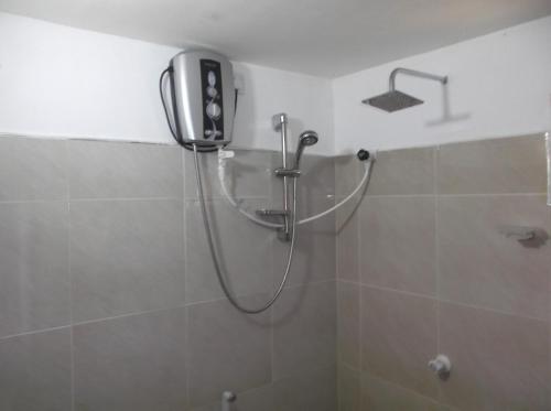 a shower in a bathroom with a phone on the wall at Disna Homestay in Habarana