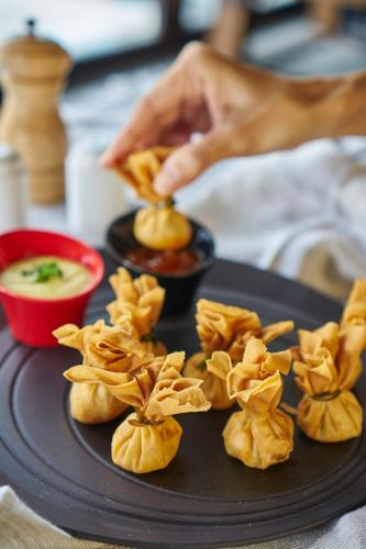 a plate of food with wontons on a table at The Sintesa Residence Jimbaran in Jimbaran