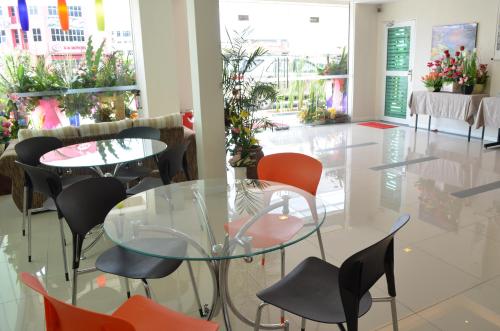 a dining room with a glass table and chairs at Hotel Asia in Kuah