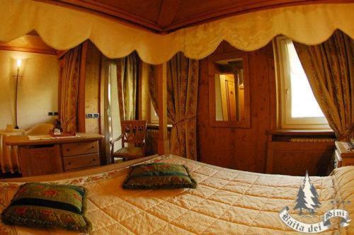 a bedroom with a large bed with pillows on it at Hotel Baita Dei Pini in Bormio