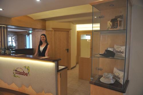 a woman is standing at a counter in a store at Aktiv-Hotel Traube am Mieminger Sonnenplateau in Wildermieming