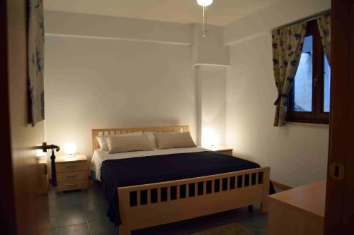 - une chambre avec un lit doté d'une couette bleue et d'une fenêtre dans l'établissement Light Blue House, à Letojanni