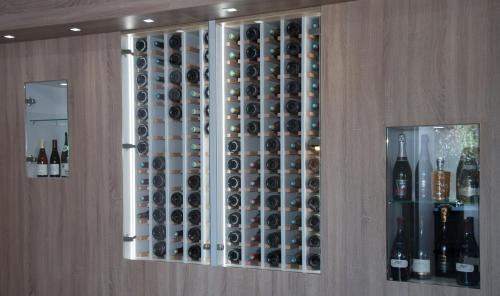 a wine cabinet with a bunch of wine bottles at Logis Aux Maisons in Maisons-lès-Chaource