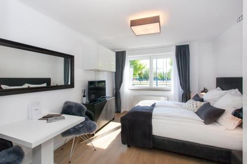 a bedroom with a bed and a desk and a window at Main Apartment Frankfurt Offenbach in Offenbach