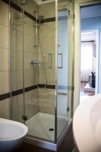a shower with a glass door next to a sink at Albergo Diffuso Zoncolan in Ovaro