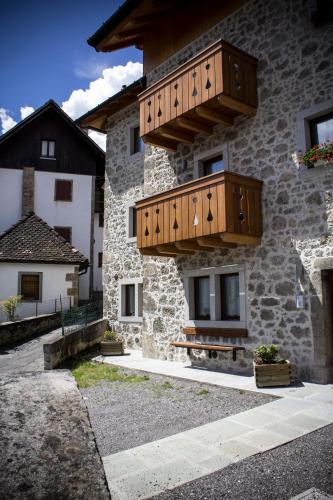 a building with wooden balconies on the side of it at Albergo Diffuso Zoncolan in Ovaro