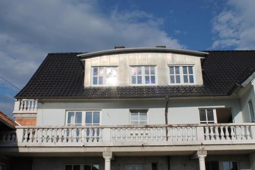 een groot wit huis met een wit balkon bij BIO-Bauernhof Rhön in Schleid