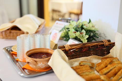 a table with a tray of food and a basket of dips at Hotel Margareta in Balatonfüred