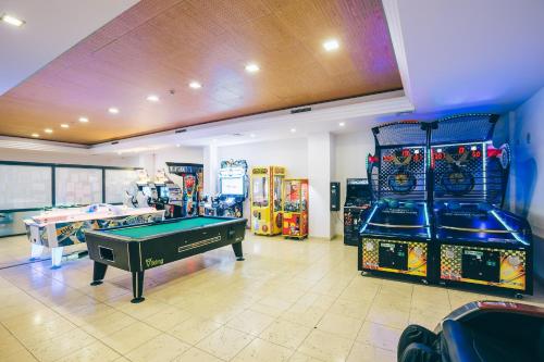 a room with a pool table and arcade games at Grand Muthu Forte do Vale in Albufeira