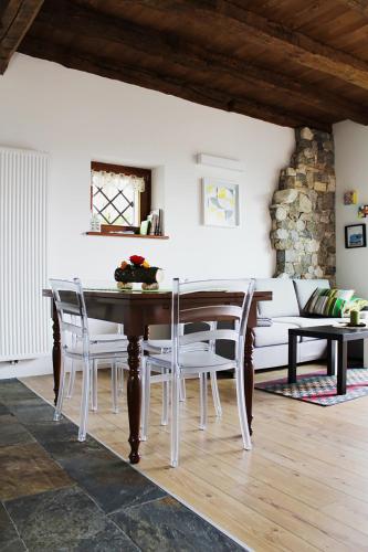 a dining room with a table and chairs and a couch at Albergo Diffuso Zoncolan in Ovaro