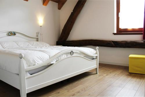 a white bed in a room with a window at Albergo Diffuso Zoncolan in Ovaro