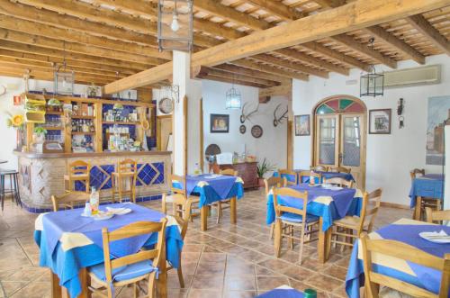 un comedor con mesas y sillas azules en Hotel Posada Casas Viejas, en Benalup-Casas Viejas