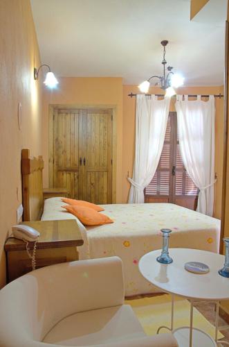 a bedroom with two beds and a table at Hotel Posada Casas Viejas in Benalup Casas Viejas