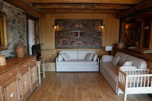a living room with a couch and a tv at Albergo Diffuso Zoncolan in Ovaro
