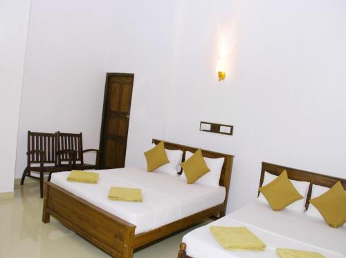 a bedroom with two beds and a chair at Villa 234 in Galle