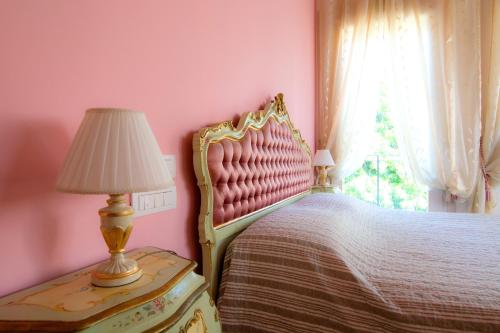 - une chambre avec un lit, une lampe et une fenêtre dans l'établissement B&B La Porta Rossa, à Noale