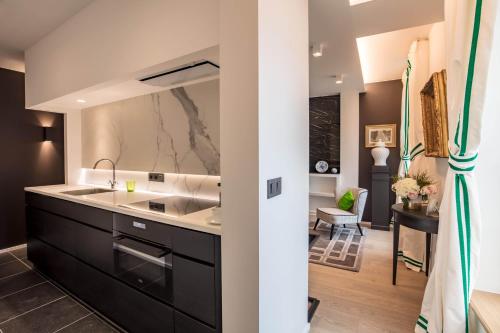 a kitchen with black cabinets and a sink at Faubourg Saint Martin in Liège