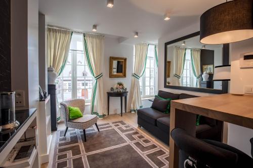 een woonkamer met een bank en een spiegel bij Faubourg Saint Martin in Luik