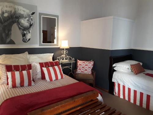 a bedroom with two beds and a horse picture on the wall at The Lighthouse Guesthouse in Colesberg