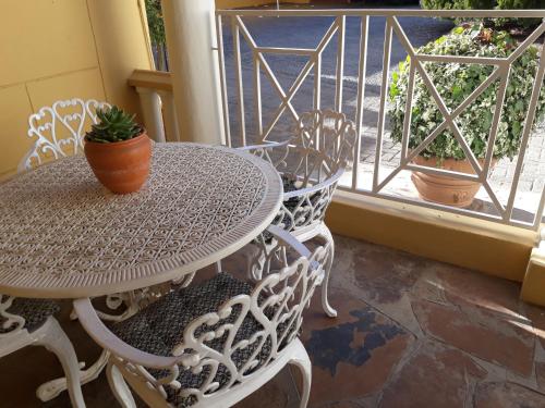 a table and chairs on a balcony with a window at The Lighthouse Guesthouse in Colesberg