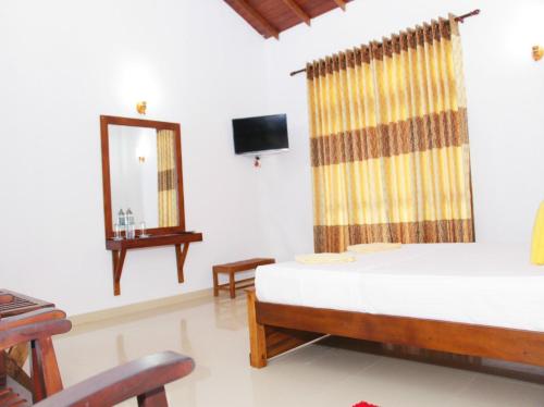 a bedroom with a bed and a mirror and a tv at Villa 234 in Galle
