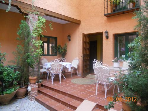 a patio with white chairs and tables on a building at Hotel Casa Rural San Antón in Chinchón