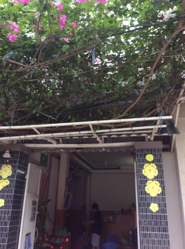 a front porch of a house with pink flowers at Nhu Y Guesthouse in Phan Rang