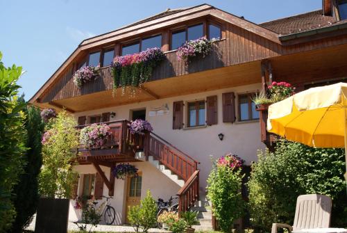 un bâtiment avec des boîtes de fleurs sur les balcons dans l'établissement B&B Le Sourire du Lac, à Sévrier