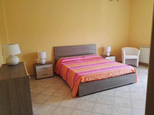 a bedroom with a bed and two lamps and a chair at Casa Catena in Francavilla di Sicilia