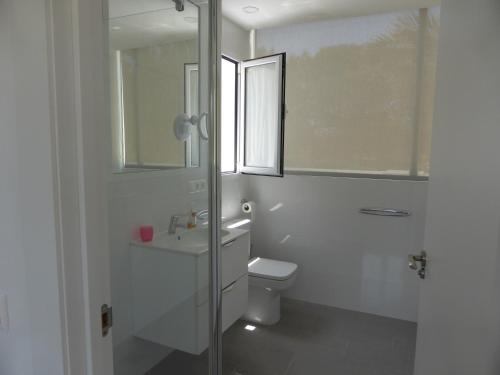 W łazience znajduje się toaleta, umywalka i lustro. w obiekcie Casa Jardin w mieście Agua Amarga