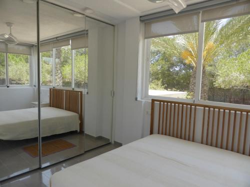 a bedroom with two beds and a large window at Casa Jardin in Agua Amarga