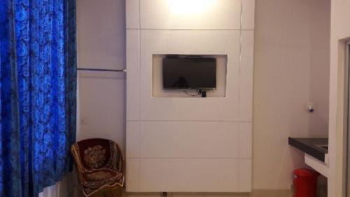 Habitación con pared y TV en la pared. en Hotel Gill Tower, en Hanumāngarh