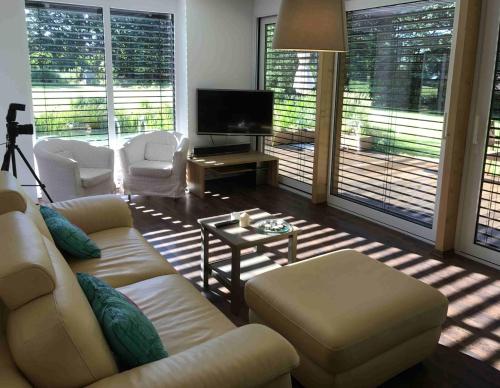 a living room with a couch and chairs and a television at Luxusní prázdninový dům in Rossitz