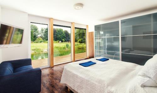 1 dormitorio con cama y ventana grande en Luxusní prázdninový dům en Rossitz