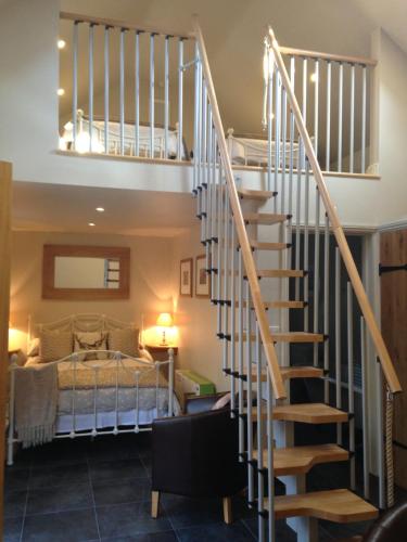 Una escalera que conduce a un dormitorio con cama en The Queens en Ludlow