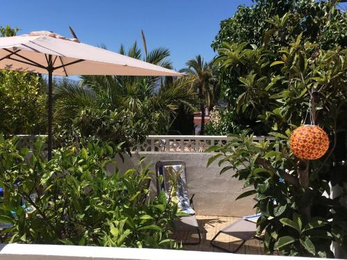 eine Terrasse mit einem Sonnenschirm, einem Tisch und Stühlen in der Unterkunft Vista Bahia II Apartment in Albir