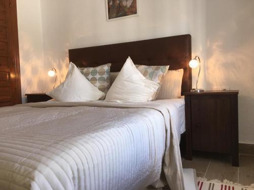 a bedroom with a large bed with white sheets and pillows at Vista Bahia II Apartments- top floor with balcony views & ground floor with garden and BBQ in Albir