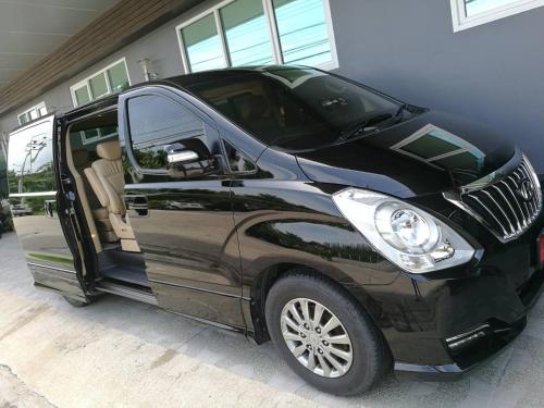 a black car parked in a garage with its door open at RoomQuest Suvarnabhumi Airport Romklao Soi 6 in Lat Krabang